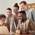 pexels-photo-3182812-3182812 A group of diverse young professionals happily collaborating around a laptop indoors.