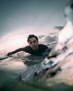 Surfer focused A determined and focused surfer navigates the ocean waves at sunset