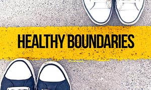 Black and white sneakers standing on a yellow line labeled "Healthy Boundaries."