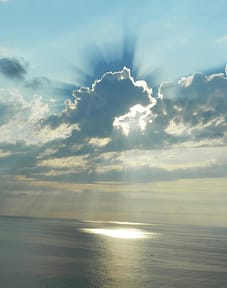 pexels-photo-160320-160320 A stunning ocean sunset with sun rays breaking through dramatic clouds.