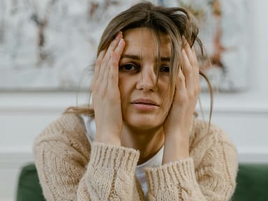pexels-photo-7699305-7699305 Woman looking distressed with hands on head, expressing worry indoors.