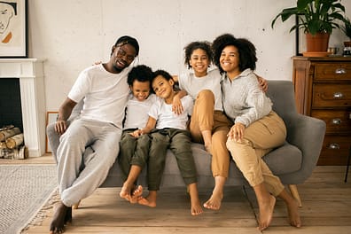 Family sitting on couch Family smiling and enjoying each other