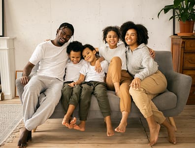 Family sitting on couch Family smiling and enjoying each other